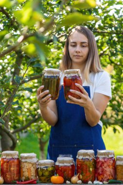 Doğanın arka planında salatalık konservesi yapan bir kadın. Seçici odak.