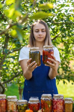 Doğanın arka planında salatalık konservesi yapan bir kadın. Seçici odak.
