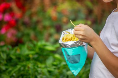 Paketten cips yiyen bir çocuk. Sağlıksız gıda konsepti.