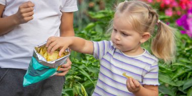 Kız ve erkek paket halinde cips yiyorlar. Çocuk