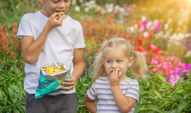 Kız ve erkek paket halinde cips yiyorlar. Çocuk