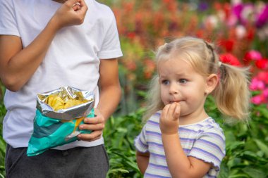 Kız ve erkek paket halinde cips yiyorlar. Çocuk