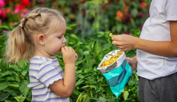 Kız ve erkek paket halinde cips yiyorlar. Çocuk