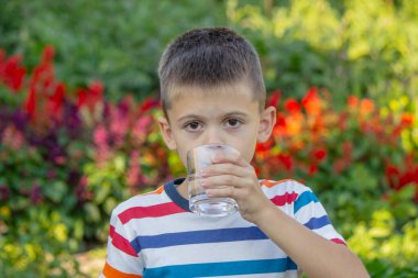 Çocuk dışarıda su içiyor. Seçici odak.