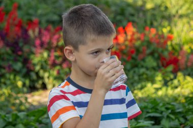 Çocuk dışarıda su içiyor. Seçici odak.