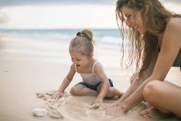 Gyermeknap. Anya és a baba játék-strand közelében. — Stock Fotó