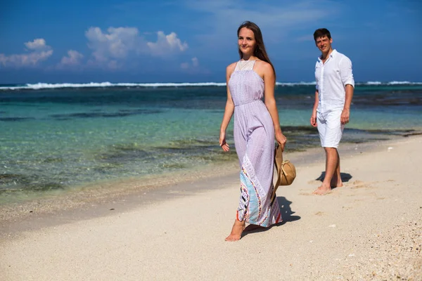 Matrimonio coppia appena sposato si tiene per mano e camminare in spiaggia — Foto Stock