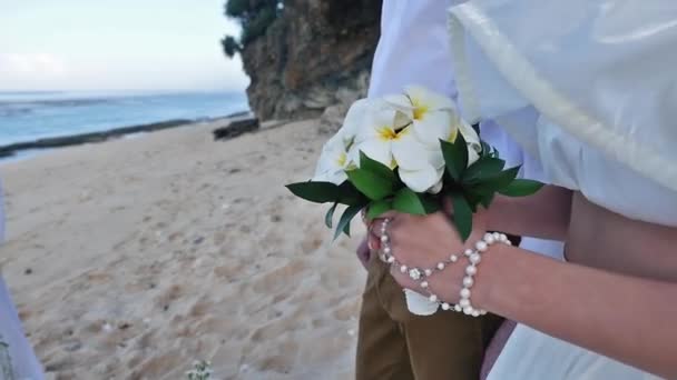 Портрет невесты проводит свадебный букет и жениха на заднем плане — стоковое видео