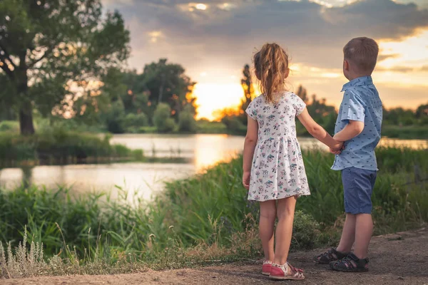 I bambini felici che camminano all'aperto al parco si tengono per mano . — Foto Stock