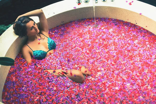 Femme bain relaxant avec des fleurs tropicales en plein air à l'hôtel de luxe — Photo