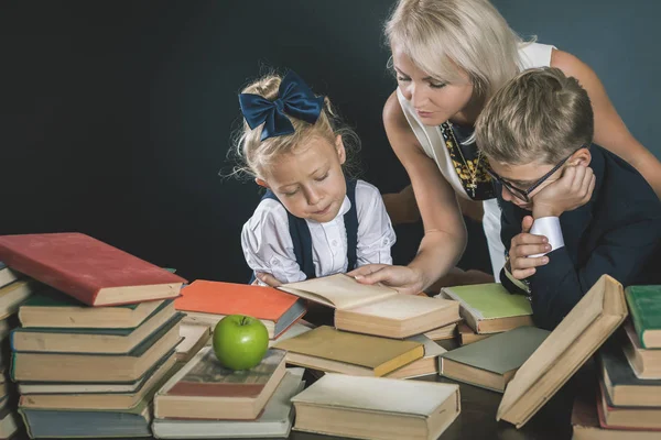 Anya vagy tanár segít részére iskola kids csinál házi feladatot, olvasás — Stock Fotó