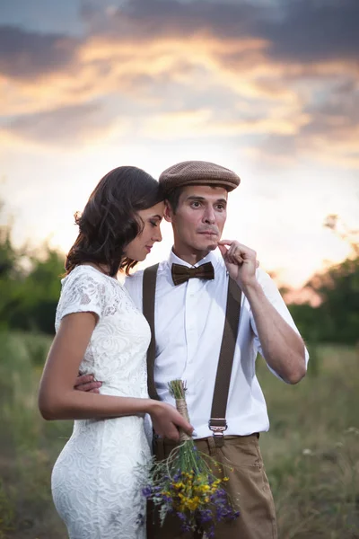 Casal jovem tem casamento em estilo rústico em campo — Fotografia de Stock