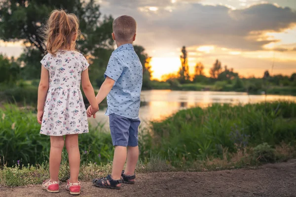 I bambini felici che camminano all'aperto al parco si tengono per mano . — Foto Stock