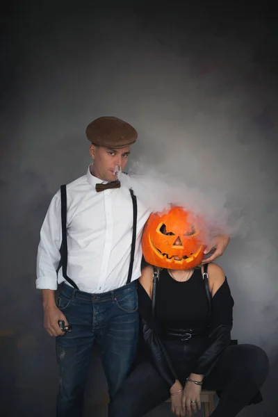 Woman with carved pumpkin on her head and man