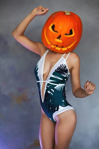 Mulher sexy com abóbora esculpida na cabeça para o Halloween — Fotografia de Stock