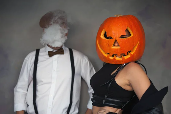 Ungewöhnliches Paar bei Halloween-Party, Frau mit Kürbis auf dem Kopf — Stockfoto