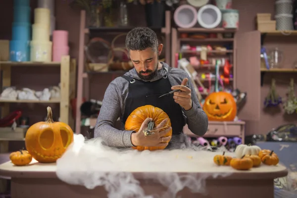 Man carves a pumpkin to decorate the Halloween