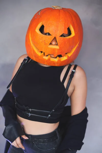 Vrouw met gebeeldhouwde pompoen op haar hoofd voor Halloween — Stockfoto