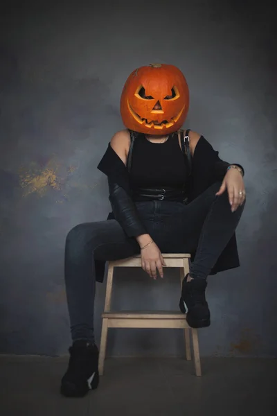 Vrouw met gebeeldhouwde pompoen op haar hoofd voor Halloween — Stockfoto