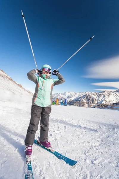 Happy child skier in mountains holds up ski poles. Ski lesson alpine school. — Stock Photo, Image