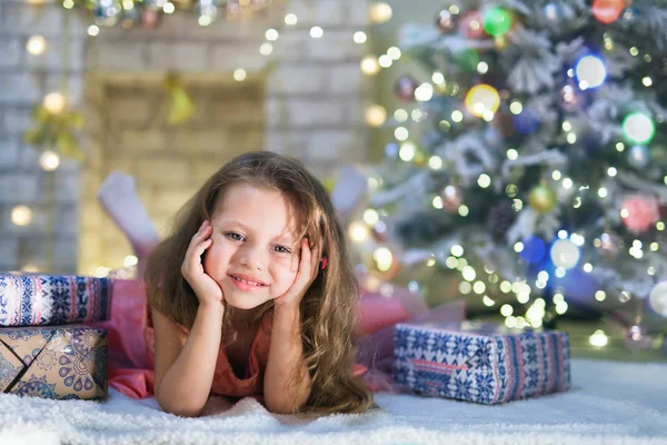 Menina criança feliz encontra-se em seu quarto crianças decoradas na noite de Natal — Fotografia de Stock