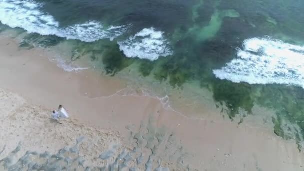 Vista aérea desde el dron de la boda pareja caminando en la playa . — Vídeos de Stock