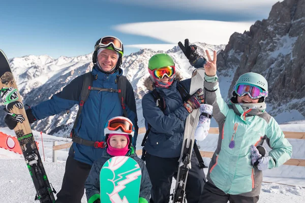 Lycklig familj skidåkning vid bergen. Barn i skidskola. — Stockfoto