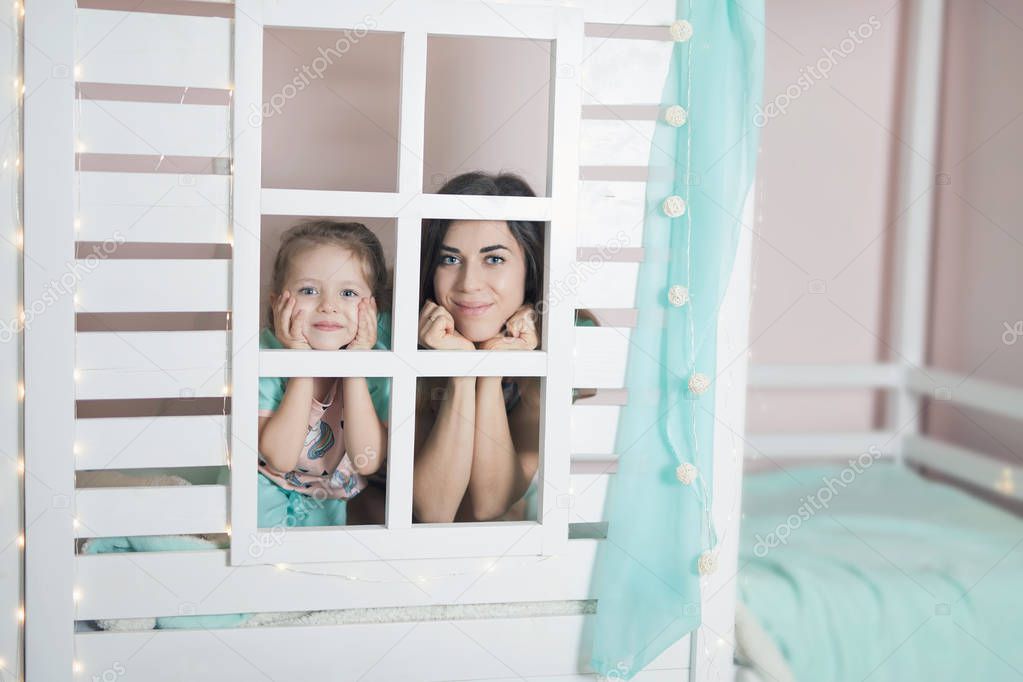 Happy mother and child preparing for sleep in children house