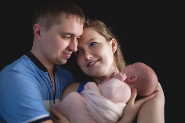 Padre y madre sostienen un bebé, concepto de cuidado familiar recién nacido —  Fotos de Stock