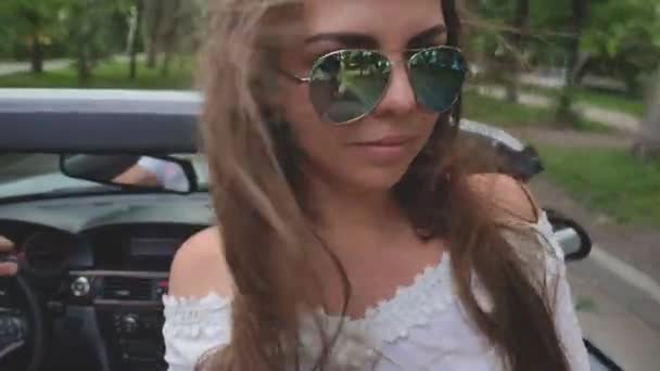 Pareja joven tiene unas vacaciones conduciendo un cabriolet blanco — Vídeo de stock