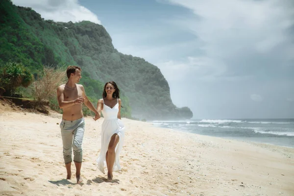 Glückliches Paar, das am Strand spazieren geht, auf bali reist. — Stockfoto