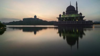 Zaman atlamalı 4k görüntüleri, güzel dramatik gündoğumu, Putrajaya Cami ile su yansıması. Yukarı eğimli