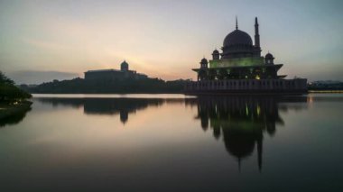 Zaman atlamalı 4k görüntüleri, güzel dramatik gündoğumu, Putrajaya Cami ile su yansıma. 