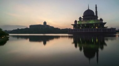 Zaman atlamalı 4k görüntüleri, güzel dramatik gündoğumu, Putrajaya Cami ile su yansıması. Sağa çevir