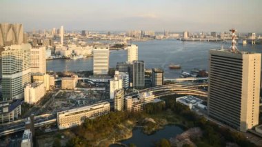 Tokyo şehir merkezindeki Kyu Shiba Rikyu Bahçesi ve Gökkuşağı Köprüsü 'ne bakan ve hareket bulanık arazi ve su taşıma hareketiyle hava görüntüsü zaman aşımı. 