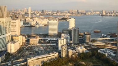 Tokyo şehir merkezindeki Kyu Shiba Rikyu Bahçesi ve Gökkuşağı Köprüsü 'ne bakan ve hareket bulanık arazi ve su taşımacılığı yapan hava görüntüsü zamanaşımı. Sağa çevir