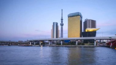 Tokyo şehrinin ufuk çizgisi, Tokyo Gökyüzü Ağacı, Sumida Nehri 'nde gün batımının 4k süreleri. Sağa çevir