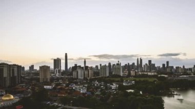 Kuala Lumpur şehrinin ufuk çizgisinde günbatımı sahnesinin hava zaman atlaması. Sağa çevir