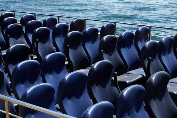 Синий пассажир пустые места на лодке удовольствия на пирсе, много синих мест, нет людей, на фоне моря, концепция лета. концепция путешествия
