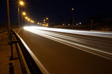 Arka plan ışığı ile gece boyunca boş asfalt yol rotaları. Gece araba tünelde ışık yollar ile kentsel sahne. Uzun pozlama.