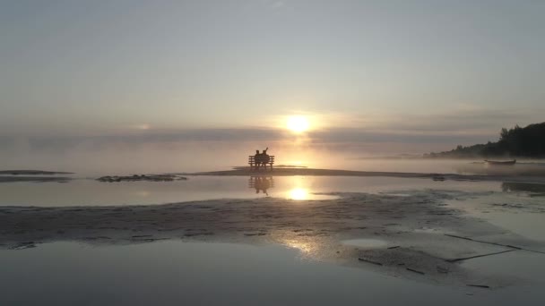 A loving couple meets the sunrise on the lake. — Stock Video