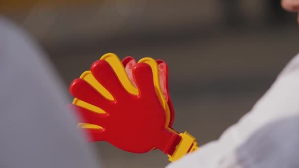 Cheering athletes with applause from plastic palms. — Stock Video