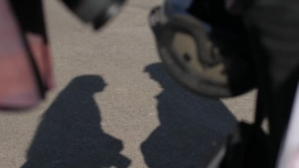 Shadow of a biker man zoenen de schaduw van een vrouw fotograaf. — Stockvideo