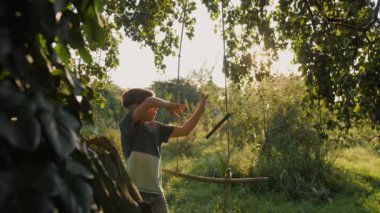Genç bir çocuk salıncağa koşar ve sallanmaya başlar..