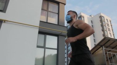Genç bir adam tıbbi bir maske takıyor..