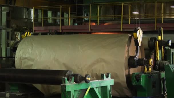 Une grue de production soulève un grand rouleau de papier manufacturé. — Video