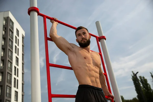 Çıplak gövdeli genç ve yakışıklı bir sporcu..