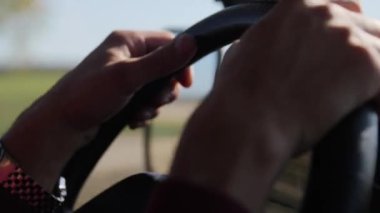 Sürücünün elleri direksiyonu tutarken yakınlaşıyor. SUV sürüyorum..