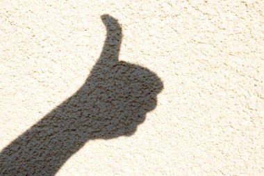 Işık duvarındaki bir elin gölgesi. Serbest el gölgesi. Gibi imzalayın, iyi, harika