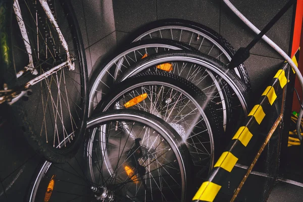 Services professional washing of bicycle in the workshop. Close-up of hand Young Caucasian stylish man doing bicycle cleaning using an automatic electric water pump. Sprays scatter from the pressure.